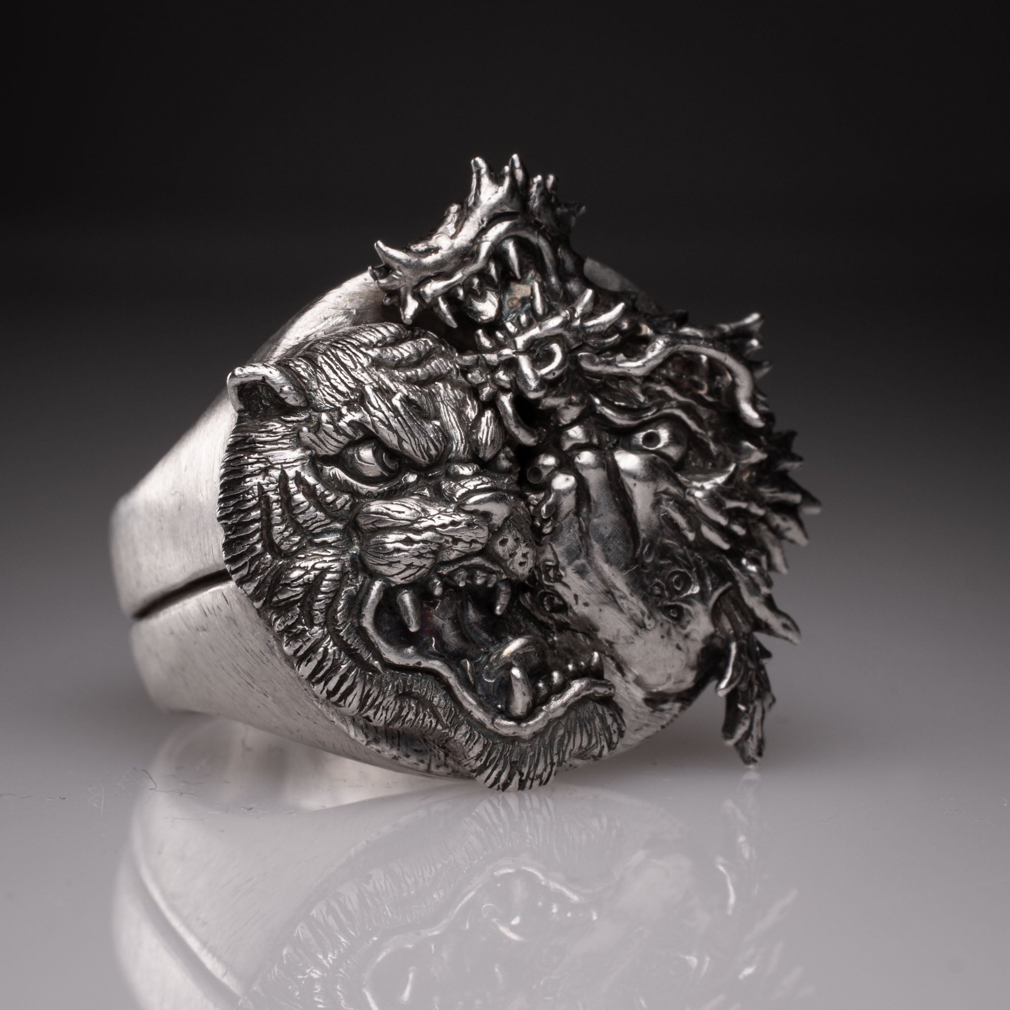 Two 925 silver rings forming a Yin Yang circle when joined, featuring detailed faces of a Dragon and a Tiger, handcrafted by KaijuLab.