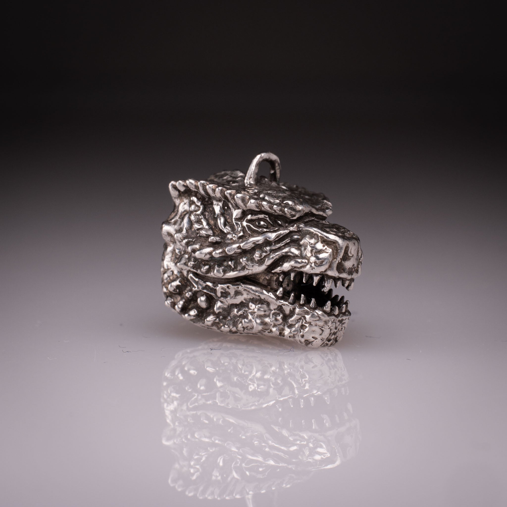 925 Sterling Silver Godzilla head pendant featuring detailed scales, sharp teeth, and oxidized finish, handcrafted by KaijuLab.