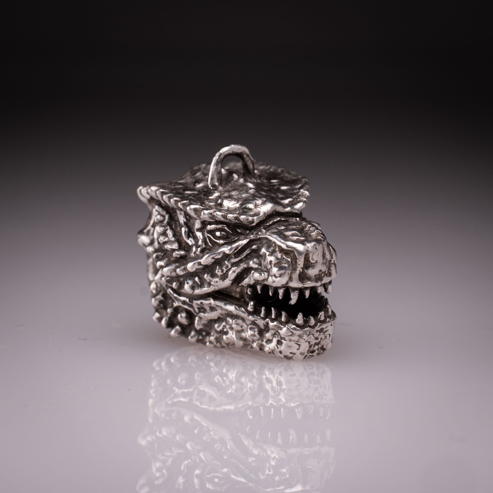 925 Sterling Silver Godzilla head pendant featuring detailed scales, sharp teeth, and oxidized finish, handcrafted by KaijuLab.
