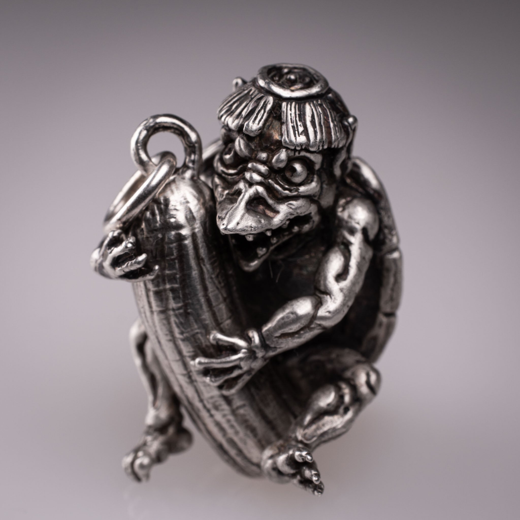 Handcrafted 925 silver full-body Kappa Yokai pendant hugging a cucumber, featuring detailed shell and tattoo art style by David Saez for KaijuLab.